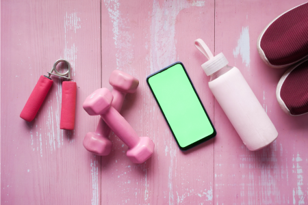 pink dumbbells, pink grip strength, pink water bottle, cellphone, pink shoes on pink hardware floor