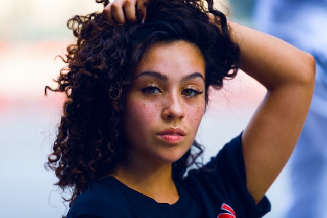 latin woman with curly hair wearing blue t-shirt