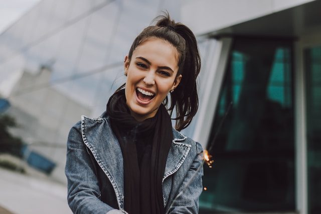 woman with black hair wearing black jacket smiling