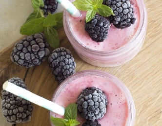 healthy strawberry shake with blackberries on top and on the side