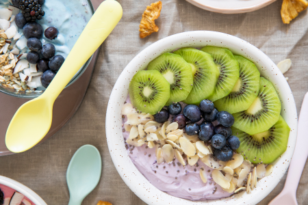 healthy snack bowl filled with greek yoghurt, almond slices, blueberries, kiwi